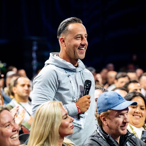 a man is holding a microphone in a crowd of people .
