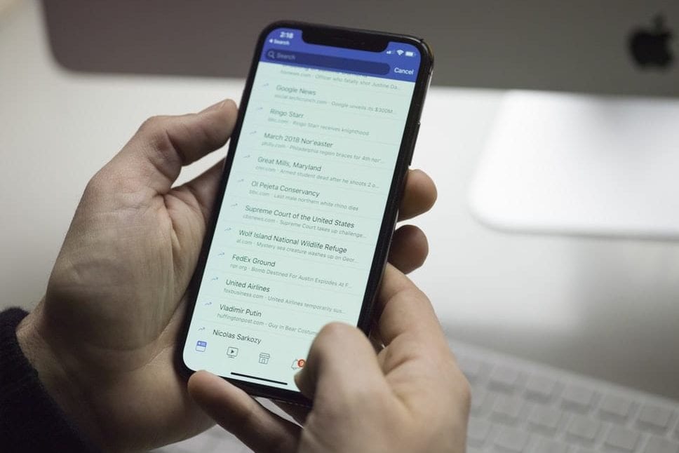 a person is holding a cell phone in their hand .