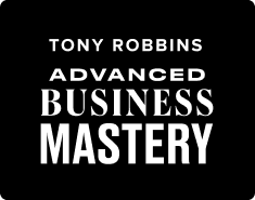 the logo for tony robbins advanced business mastery is white on a black background .