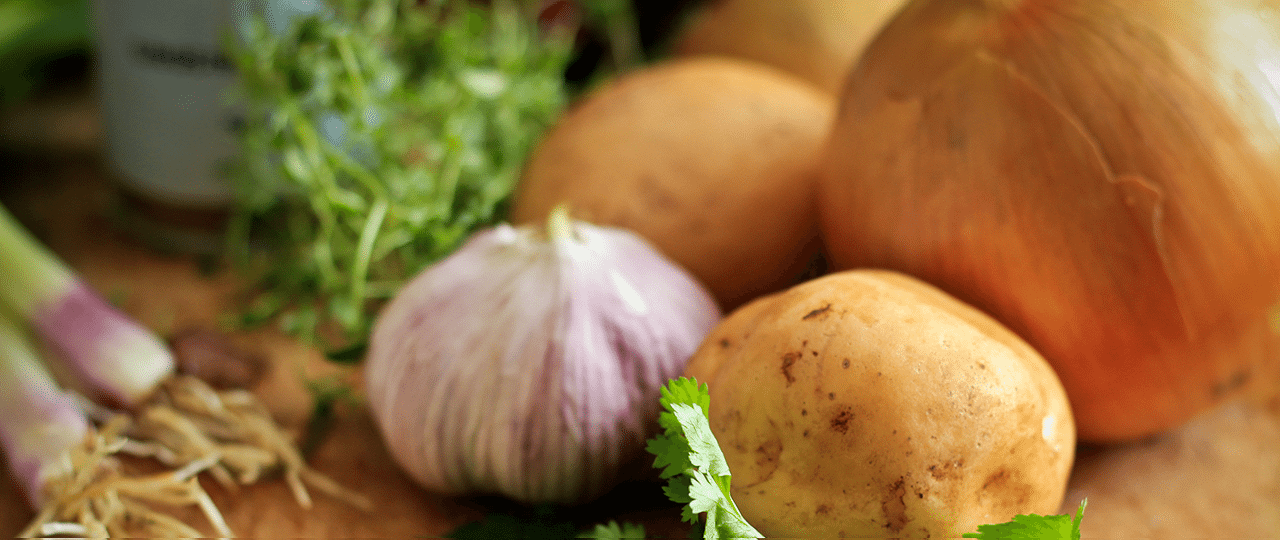 Potatoes onions garlic and other vegetables on a table