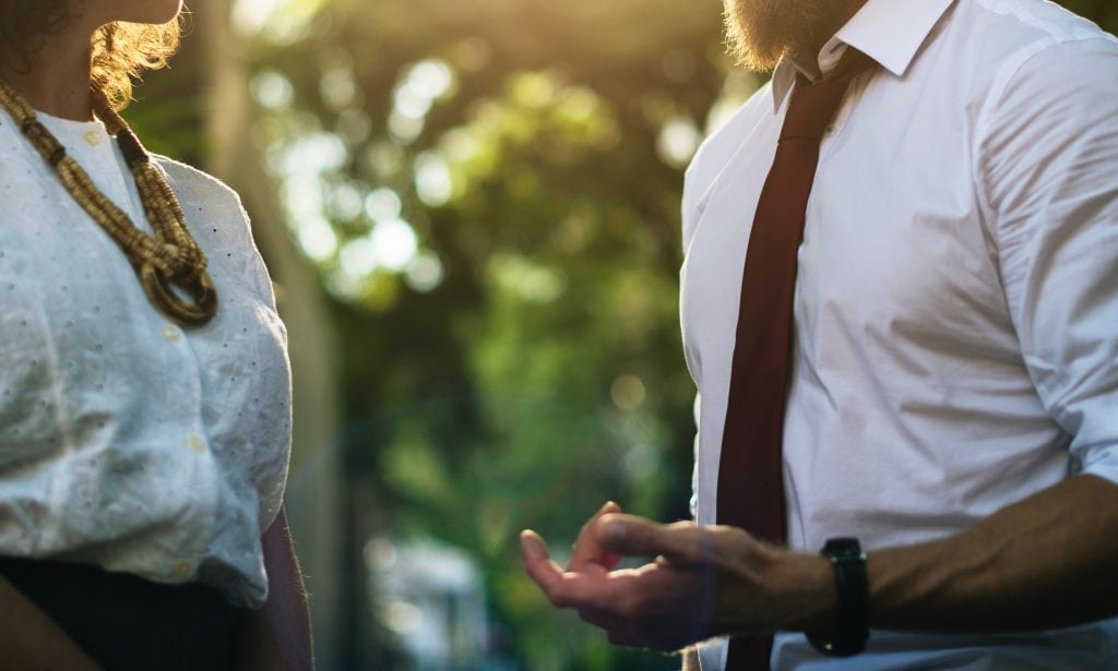 a man and a woman are talking to each other in a park .