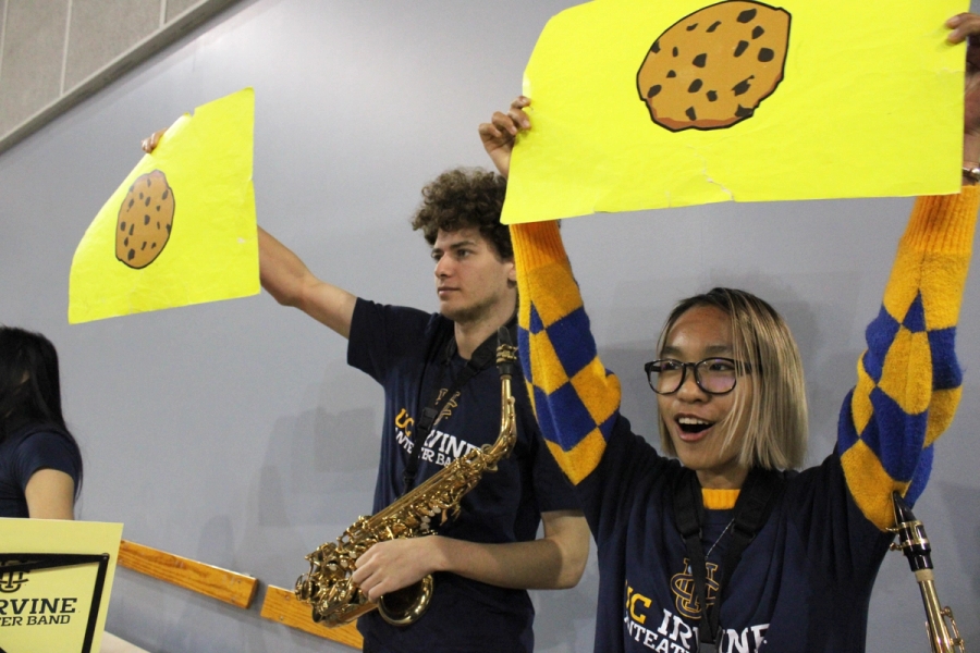 Two alto saxes holding up cookie emojis.