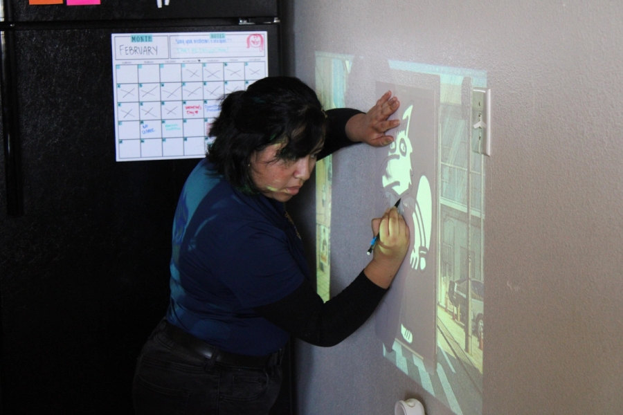 Girl tracing Peter on wall.