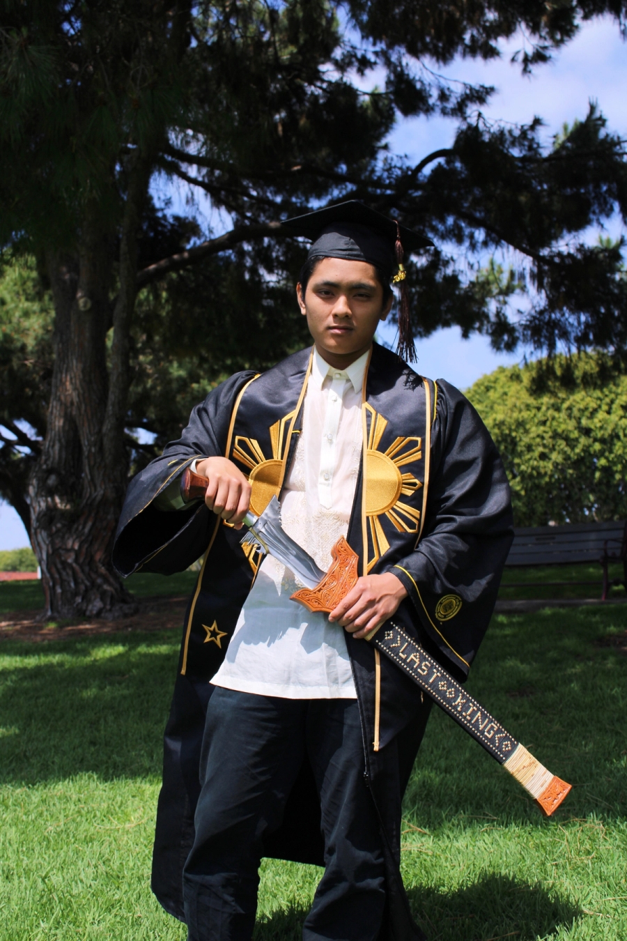Man in Filipino grad fit with large sword.