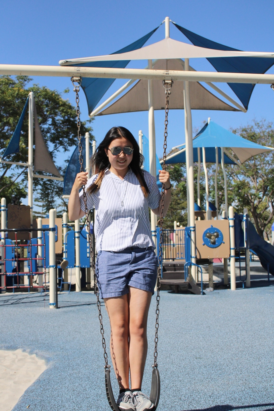 Girl standing on swing.