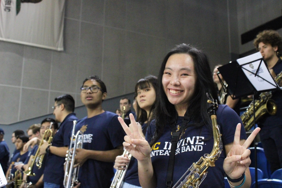 Alto sax girl posing in front of trumpets.