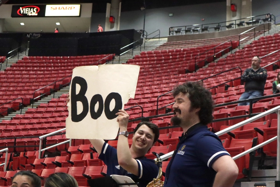 Boy holding 'Boo' sign.