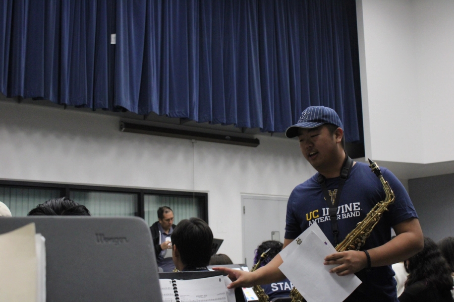 Boy with alto sax setting up music.