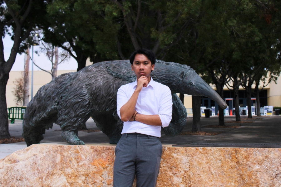 Boy thinking in front of anteater statue.