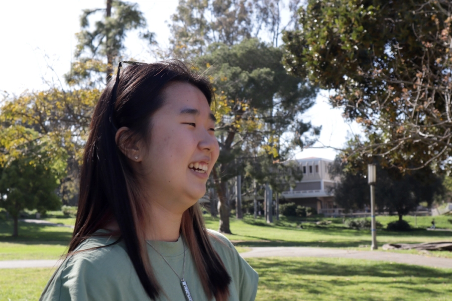 Girl in green smiling.