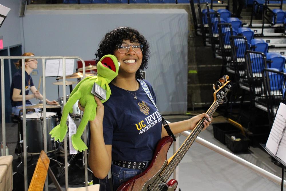Girl holding Kermit and bass.