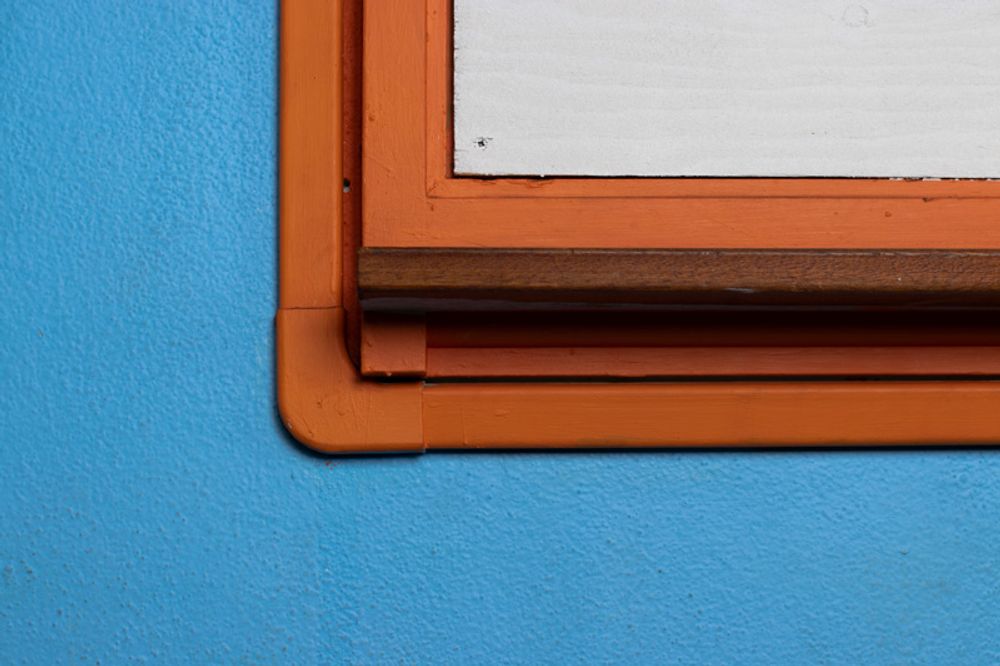 Blue wall, orange frame, white board.