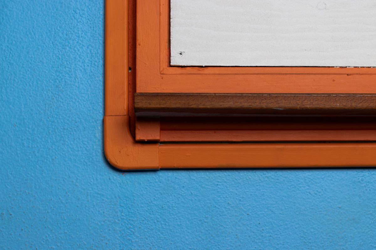 Blue wall, orange frame, white board.