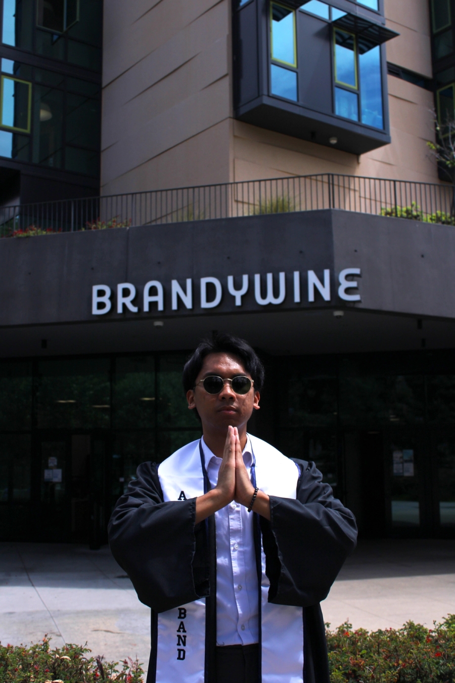 Boy praying in grad fit.