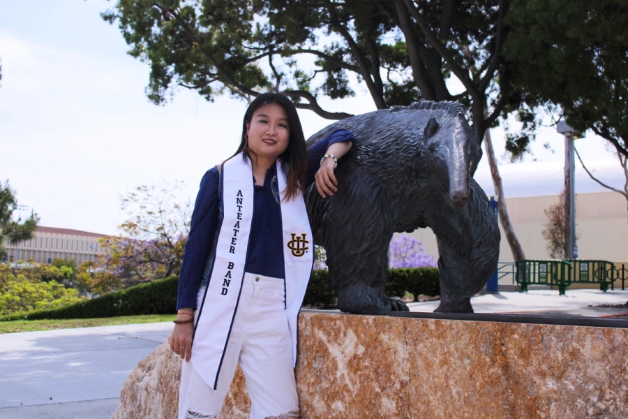 Girl leaning on anteater statue.