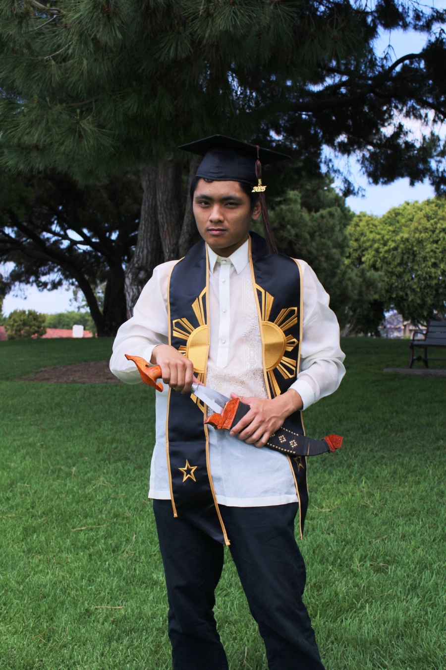 Man in Filipino stole and cap with small sword.