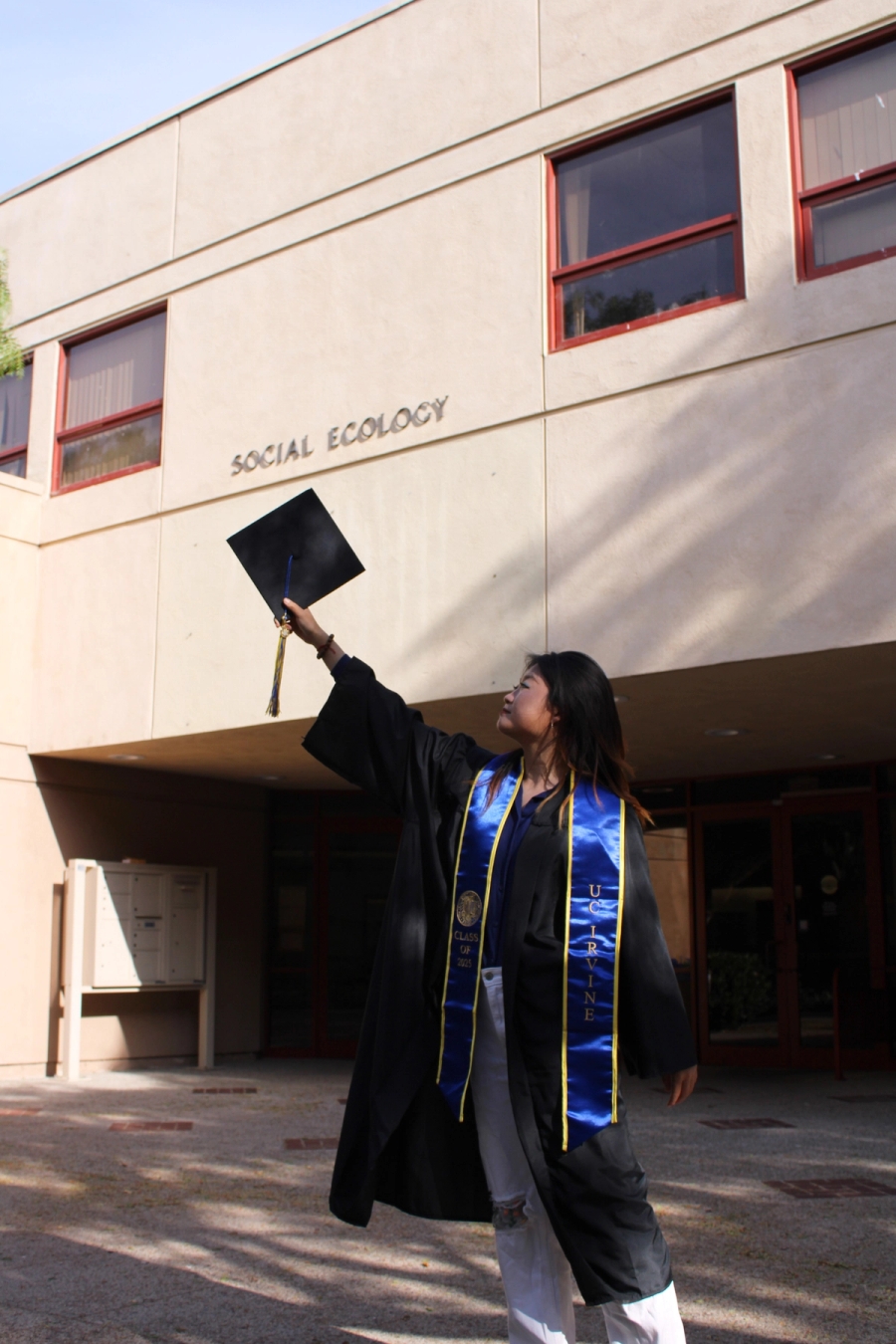 Girl holding cap up in grad fit.