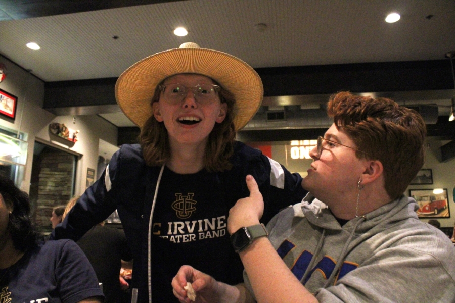 Boy pointing at girl with hat on.
