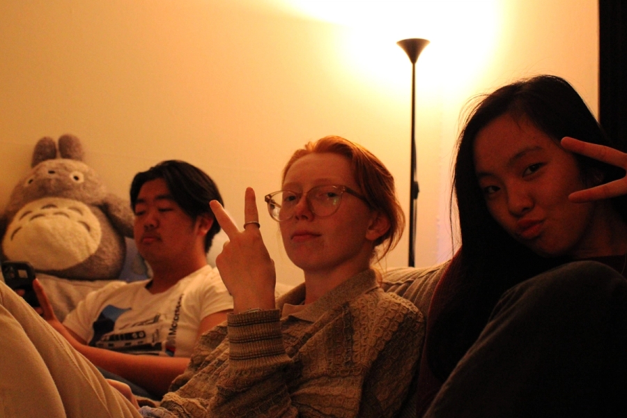 Two girls and a boy posing with peace signs.