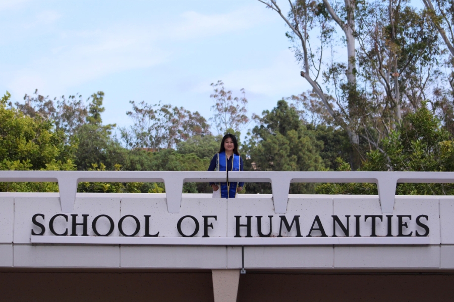 Girl standing over school sign.