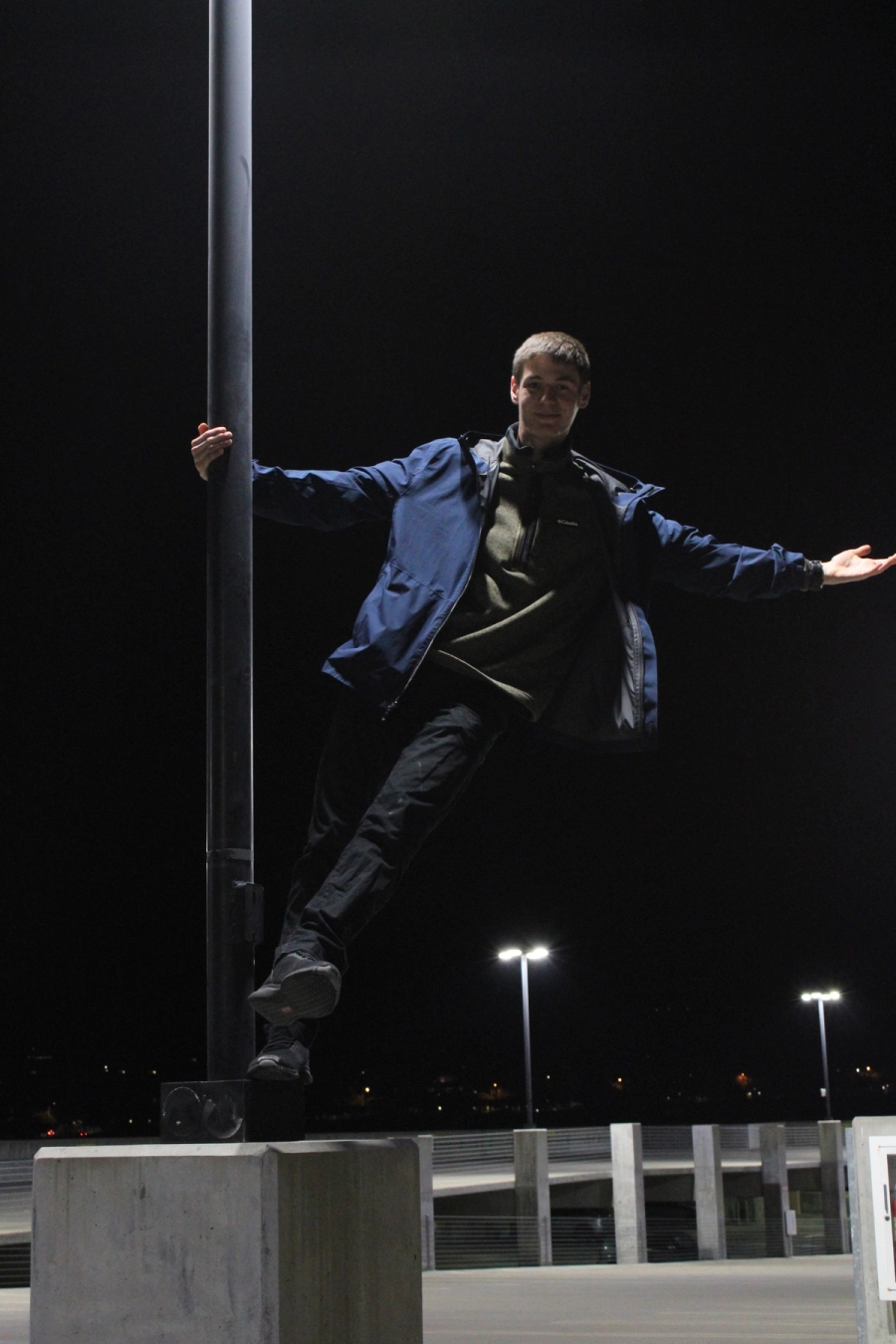 Boy swinging on lamppost.