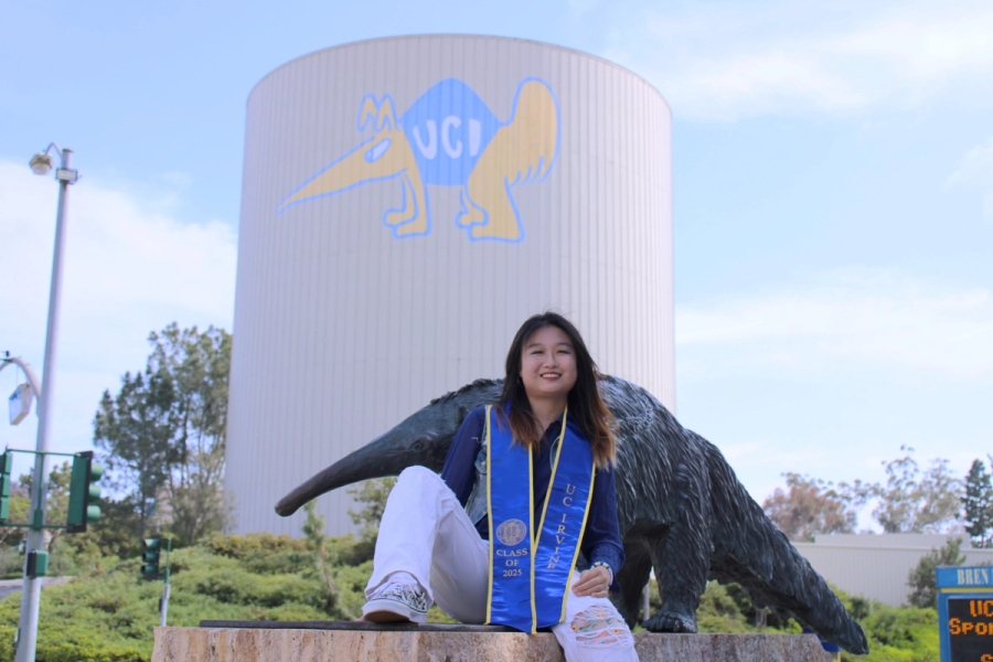 Girl sitting in front of anteater statue.