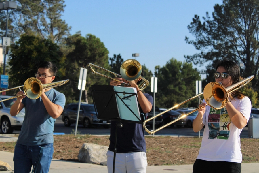 Three students playing the trombone.