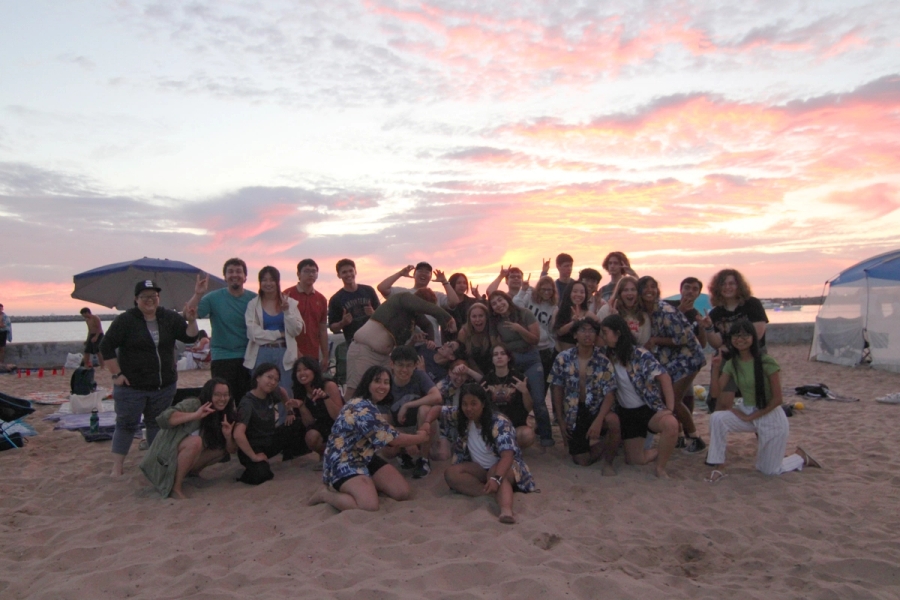 Group of students smiling at beach.