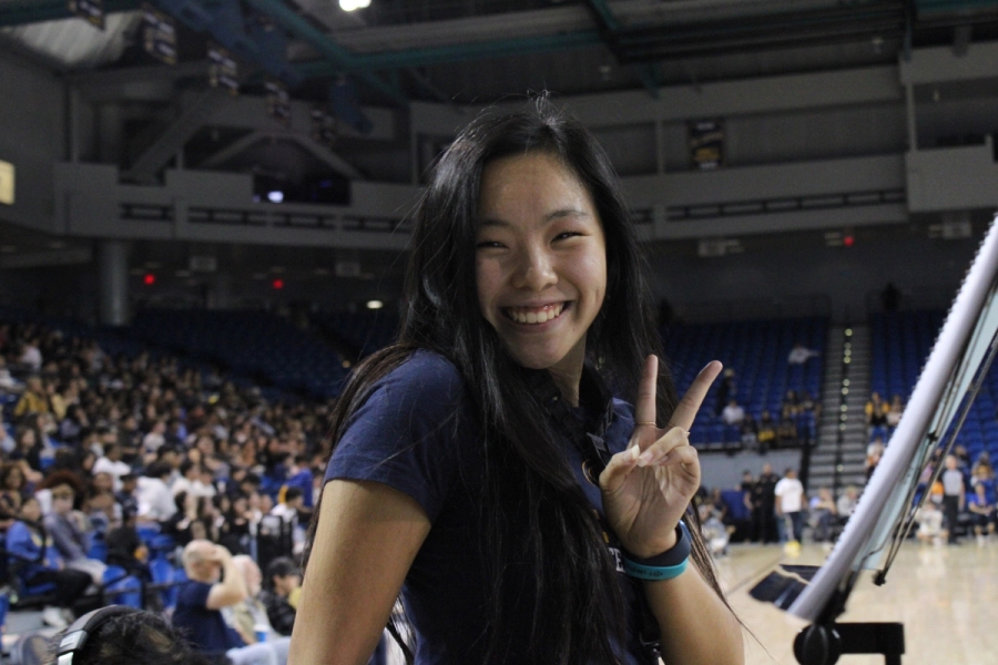 Girl holding up peace sign.