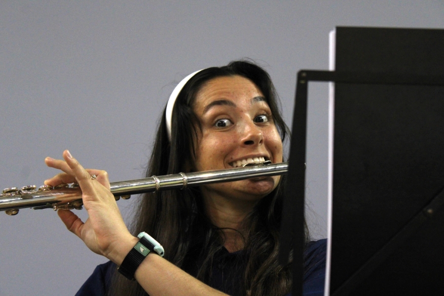 Girl staring and smiling with flute.