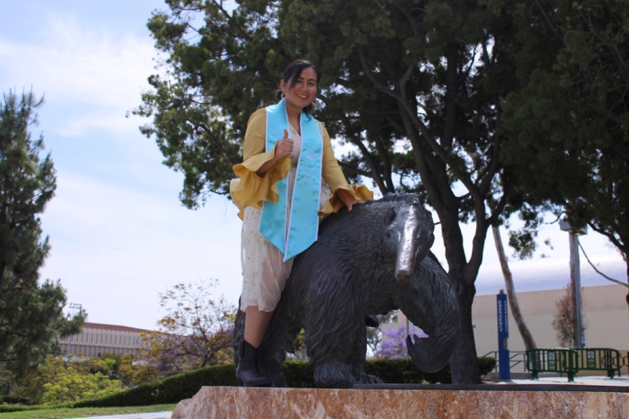 Girl sitting on anteater statue.
