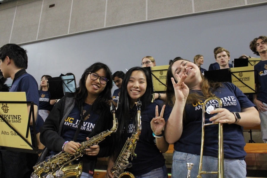 Two alto sax girls and one trombone girl smiling and posing.