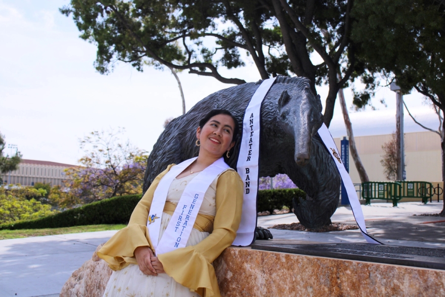 Girl leaning on anteater statue.