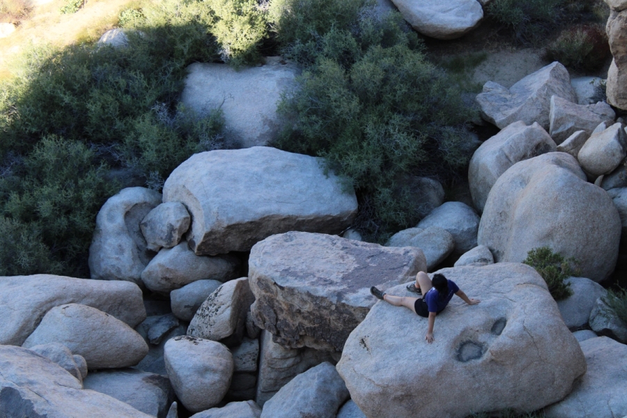 Mexican girl sitting on a rock.