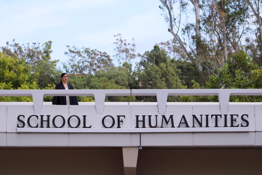 Girl posing awkwardly near school sign.