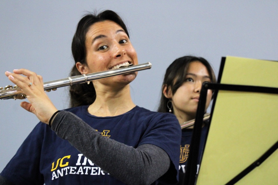 Girl smiling while playing flute.