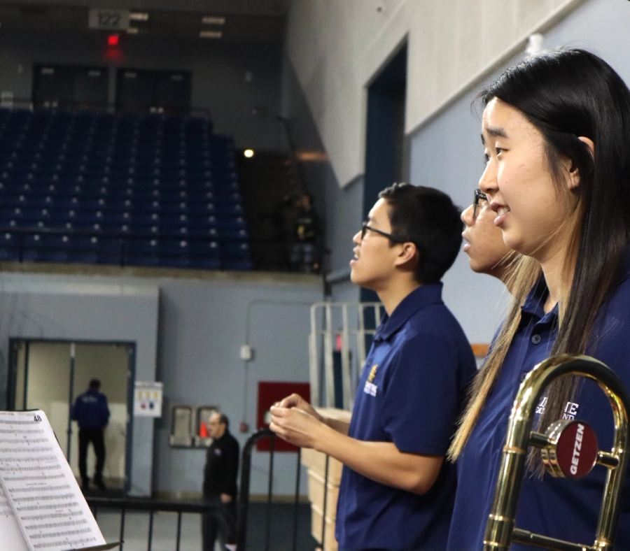 Three trombones look at the game.