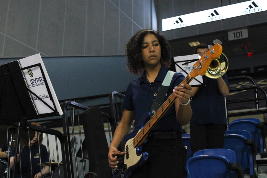 Low POV of girl playing bass.