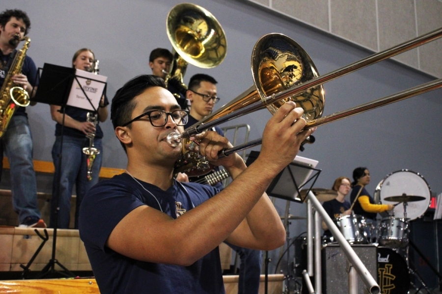Low front POV of man playing trombone.