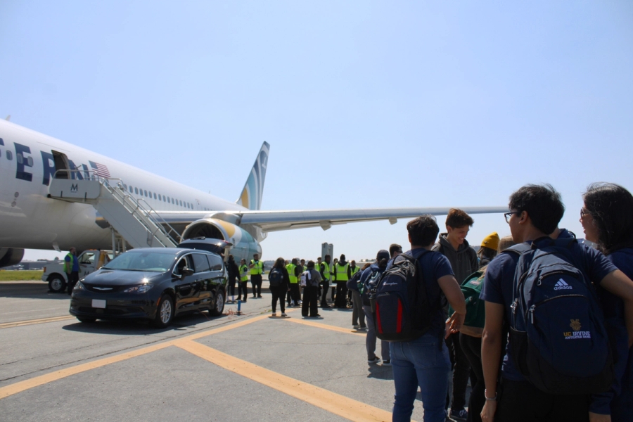Line of people waiting to get on a plane.