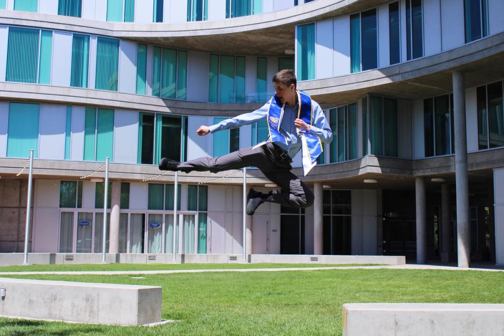 Boy doing a flying kick with UCI stole.