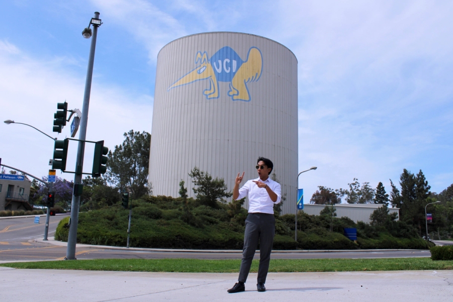 Boy pointing at zot sign in front of water tower.
