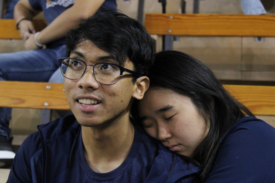 Girl sleeping on boy's shoulder.