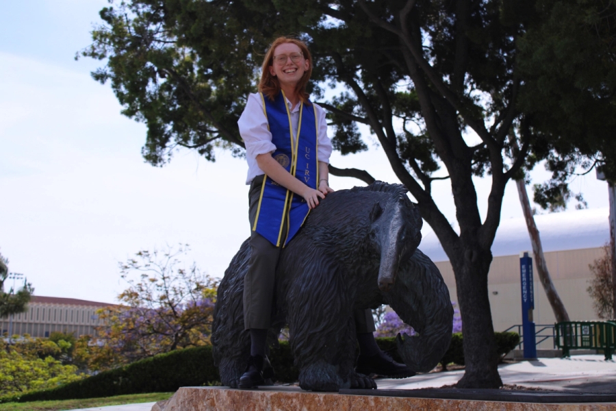 Girl sitting on anteater statue.