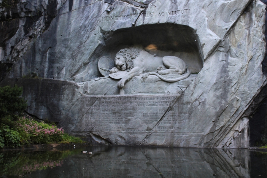 Chiseled lion in rock wall.