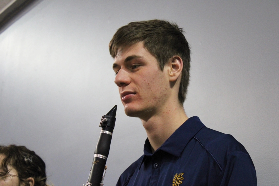 Boy with clarinet staring at music.