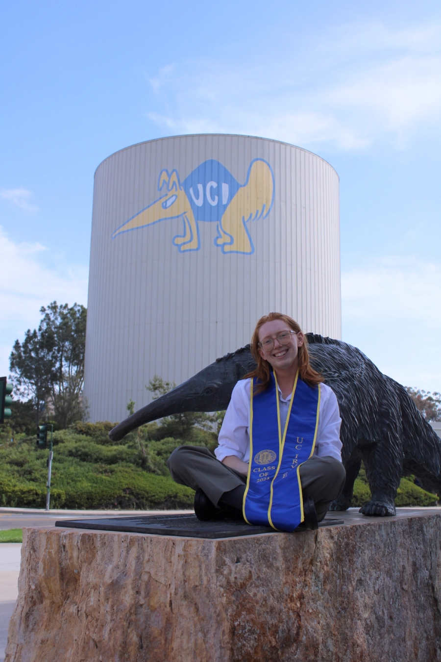 Girl sitting in front of anteater statue.