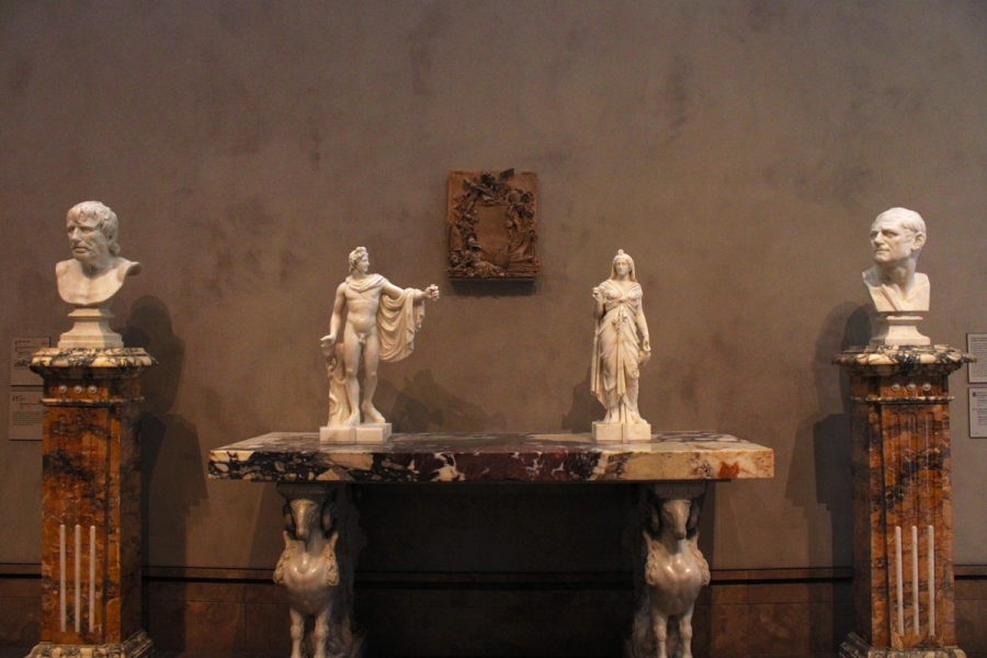 Four statues on marble platforms.