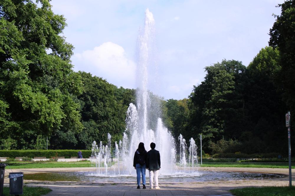 A couple admiring a water fountain.