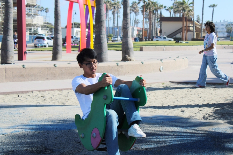 Boy riding a dinosaur attraction.